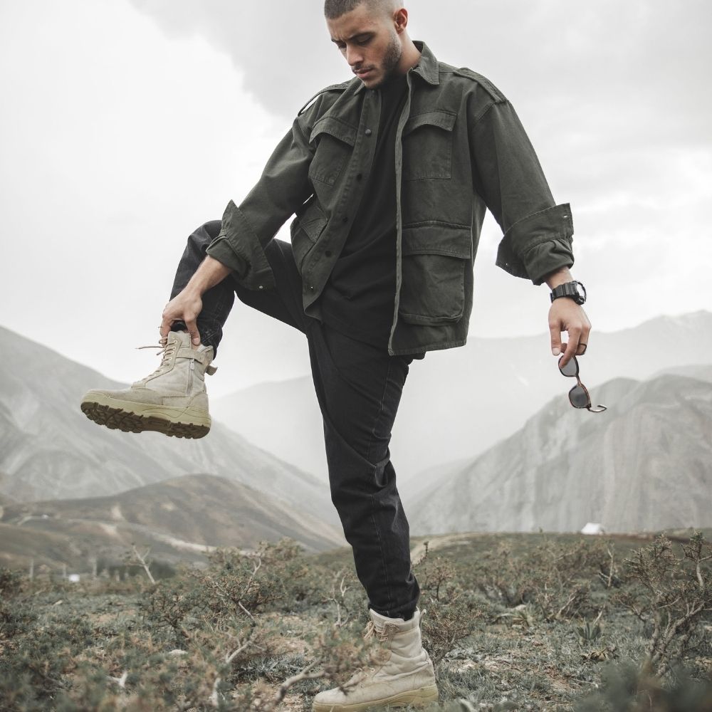 Person wearing tactical boots in a mountain outdoor environment