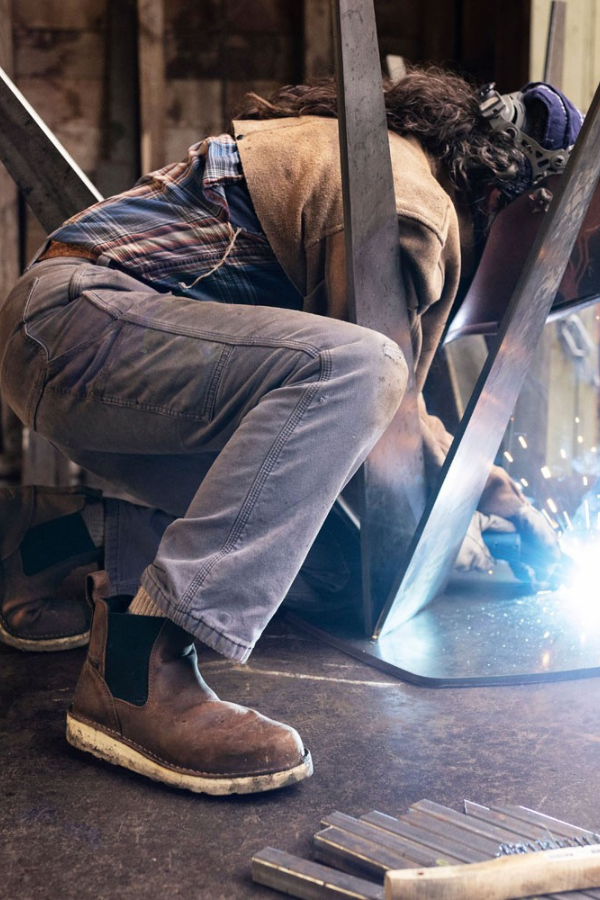 Female welder working inside a steel frame structure on a construction jobsite